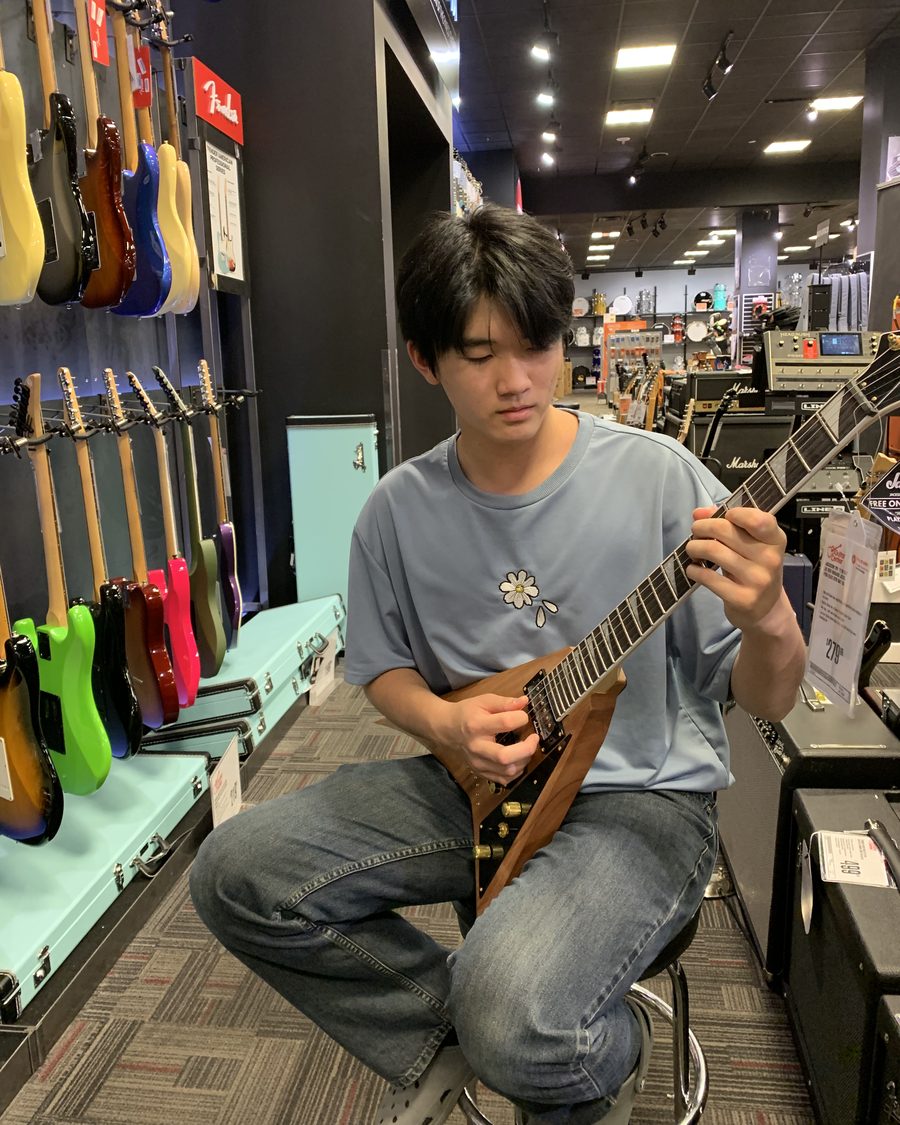 Ethan playing an electric guitar in a guitar shop